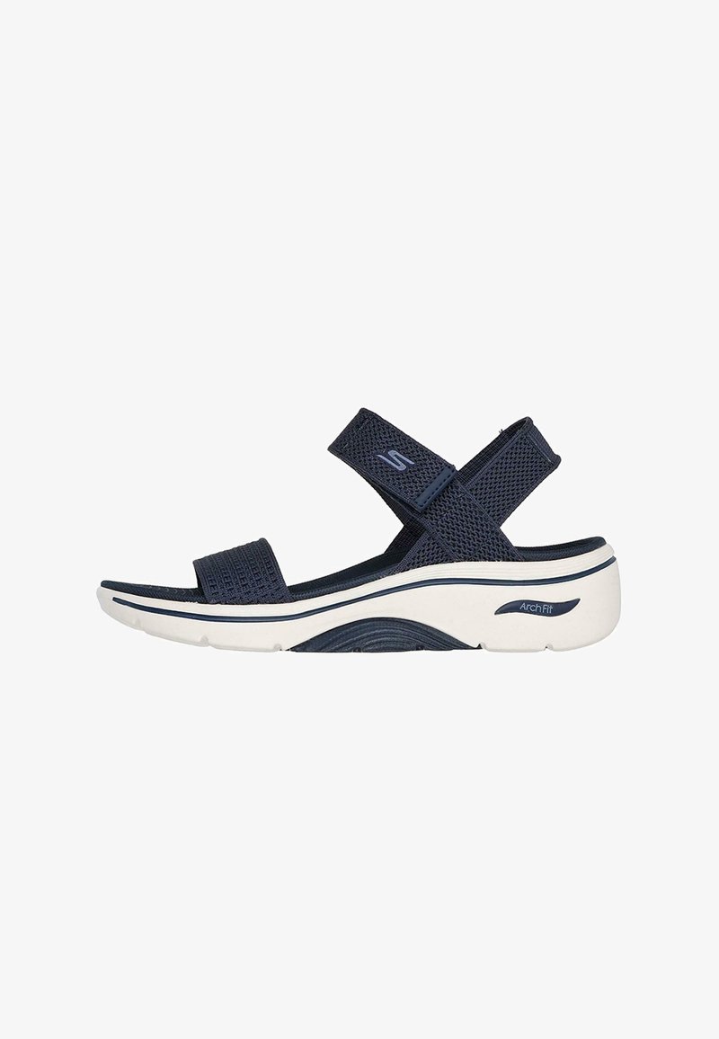 Sandalo blu navy con cinturini in rete, chiusure regolabili con velcro e una suola bianca imbottita con design di supporto per l'arco.