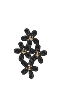 Broche de tela negra tejida en un patrón floral, con cuentas de color dorado en el centro de cada flor para darle un toque de acento.
