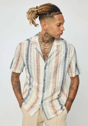 Chemise à manches courtes avec un motif rayé multicolore dans des teintes pastel. Fabriquée en tissu léger avec une coupe décontractée.