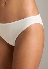 Biele bavlnené bikiny s hladkou textúrou, nízkym strihom a čistými okrajmi. Jednoduchý dizajn bez dodatočných vzorov alebo akcentov.