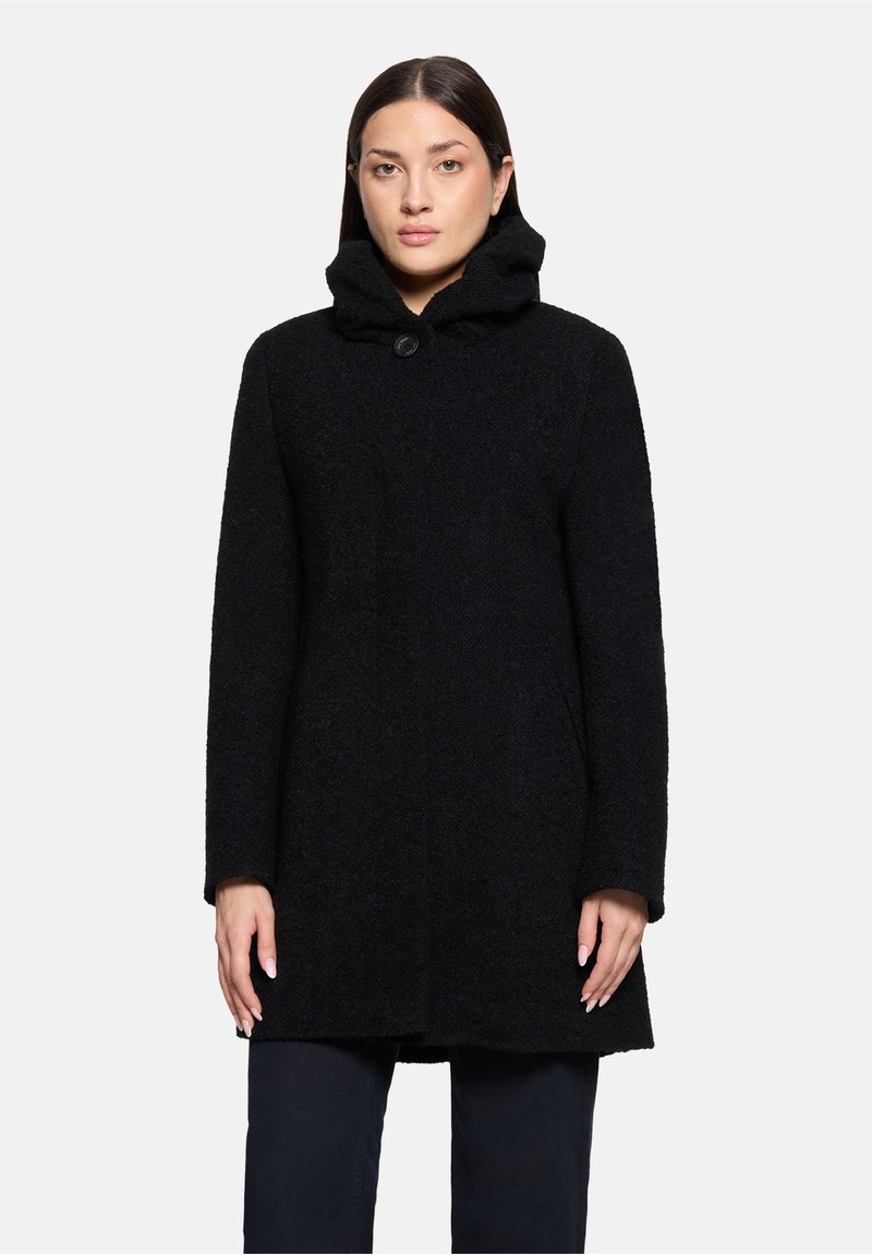 Zwarte wollen jas met een hoge kraag en een enkele knoopsluiting. Beschikt over een gestructureerd oppervlak en recht afgesneden mouwen.