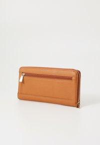 Portefeuille en cuir tan avec une fermeture éclair, poche zippée extérieure et surface texturée. Forme rectangulaire avec des accents en métal doré.