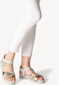 Sandales à lanières bleu clair et argent métallique avec une semelle rembourrée, dotées d'un bout ouvert et d'une texture lisse. Parfaites pour les temps chauds.