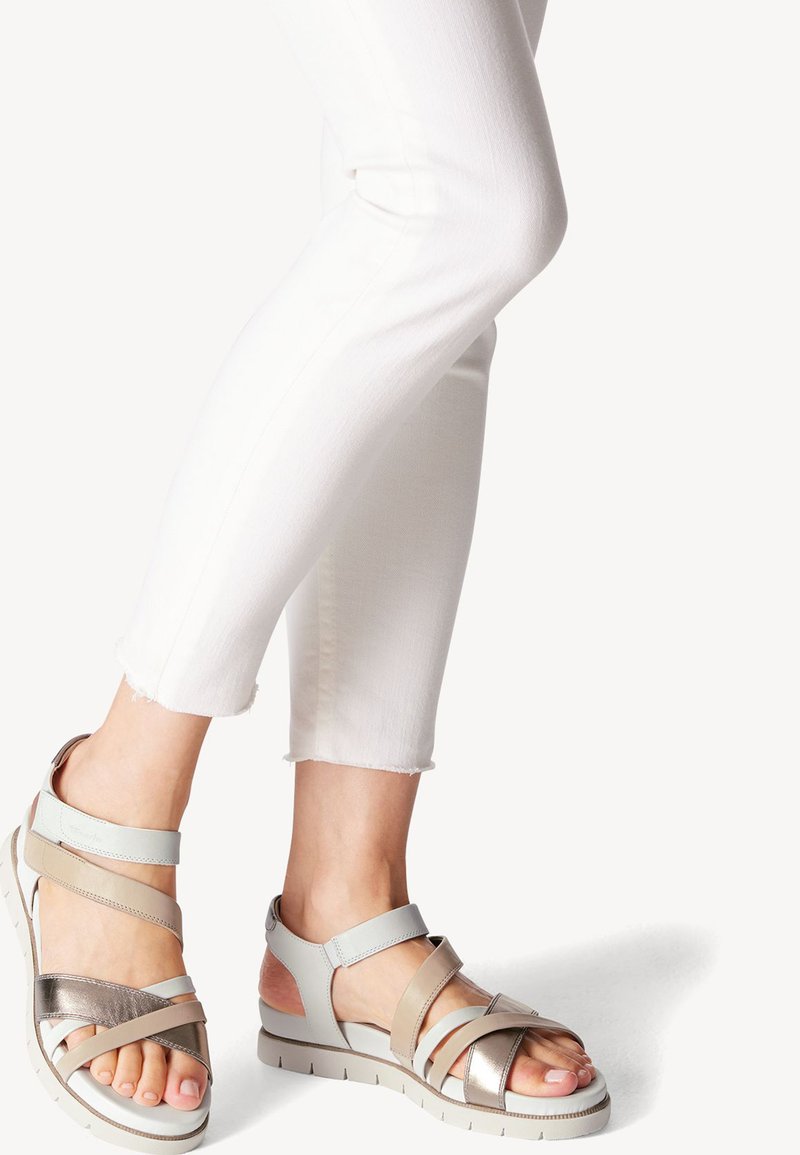 Sandales à lanières bleu clair et argent métallique avec une semelle rembourrée, dotées d'un bout ouvert et d'une texture lisse. Parfaites pour les temps chauds.