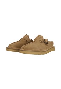 Sandfarbene Wildleder-Slipper mit runder Zehenpartie und einem verstellbaren Riemen mit einer Metall-Schnalle. Strukturiertes Obermaterial und Gummisohle.