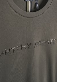 Camiseta verde oliva con el logo elevado y brillante de "ANTONY MORATO". Corte regular con un cuello redondo clásico y textura suave.