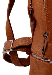 Bruine leren tas met textuur, verstelbare schouderriem, zichtbare zilveren ritsstenen en metalen ritslussen.