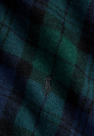 Tissu en laine vert foncé et bleu avec un motif à carreaux noirs subtil et un petit logo gris brodé au centre.
