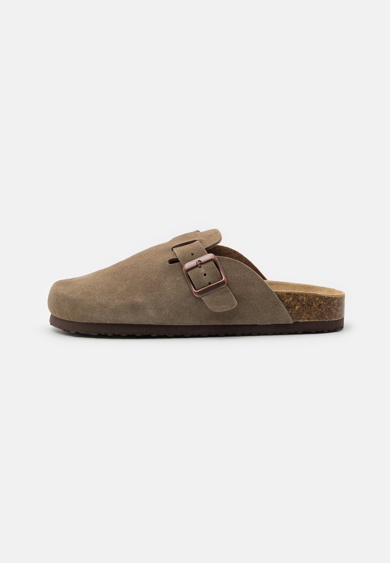 Brown suede clog with a round toe, adjustable strap, and a cork footbed. The outsole is dark with a textured design for grip.