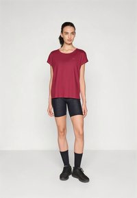 Tumesinine lühikeste varrukatega särk, mida on kombineeritud mustade tekstuursete rattapükstega ja mustade kingadega. Lihtne disain, ümmarguse kaelusega ja lahtise istuvusega.