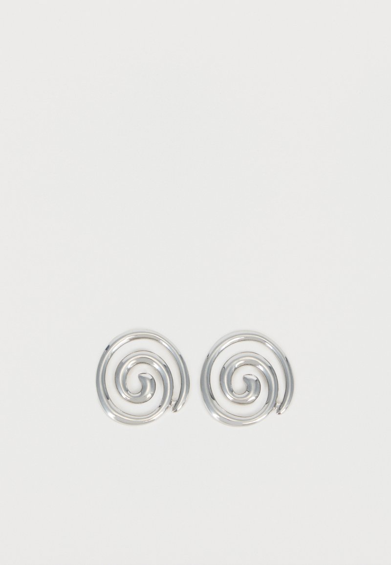 Paire de boucles d'oreilles en forme d'anneau spirale en argent avec un design lisse et arrondi sur fond blanc uni.