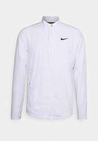 Chaqueta blanca de Nike con un cuello alto, cremallera frontal y paneles laterales de malla para mayor transpirabilidad; incluye un pequeño logo negro en el lado izquierdo del pecho.