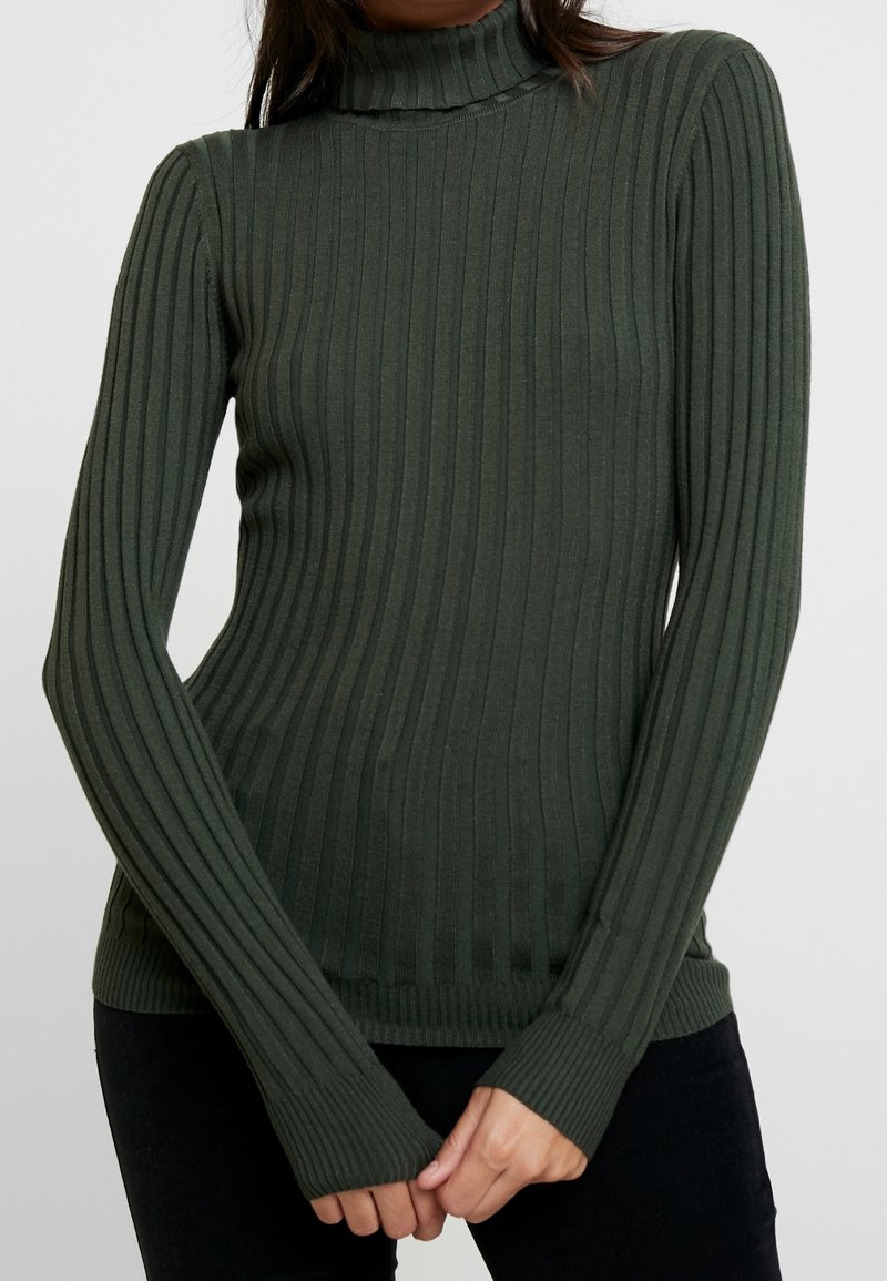 Pull à col roulé côtelé vert foncé avec des manches longues et un design ajusté. Comprend un tissu texturé et des poignets allongés pour une meilleure couverture.