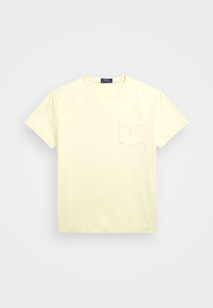 Světle žluté tričko s krátkým rukávem a kulatým výstřihem s malou kapsou na hrudi a štítkem Polo Ralph Lauren uvnitř límce.