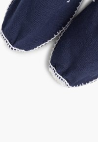 Marineblauwe katoenen instapschoenen met witte stiksels langs de randen, voorzien van een textuur en een rond toe design.