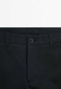 Black pants with a smooth texture, featuring a button closure and belt loops. The fabric appears durable with a subtle sheen.