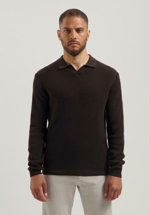 Bruine gebreide polo met lange mouwen, met een geribbelde structuur en een V-hals. Heeft fitted manchetten en een rechte zoom.