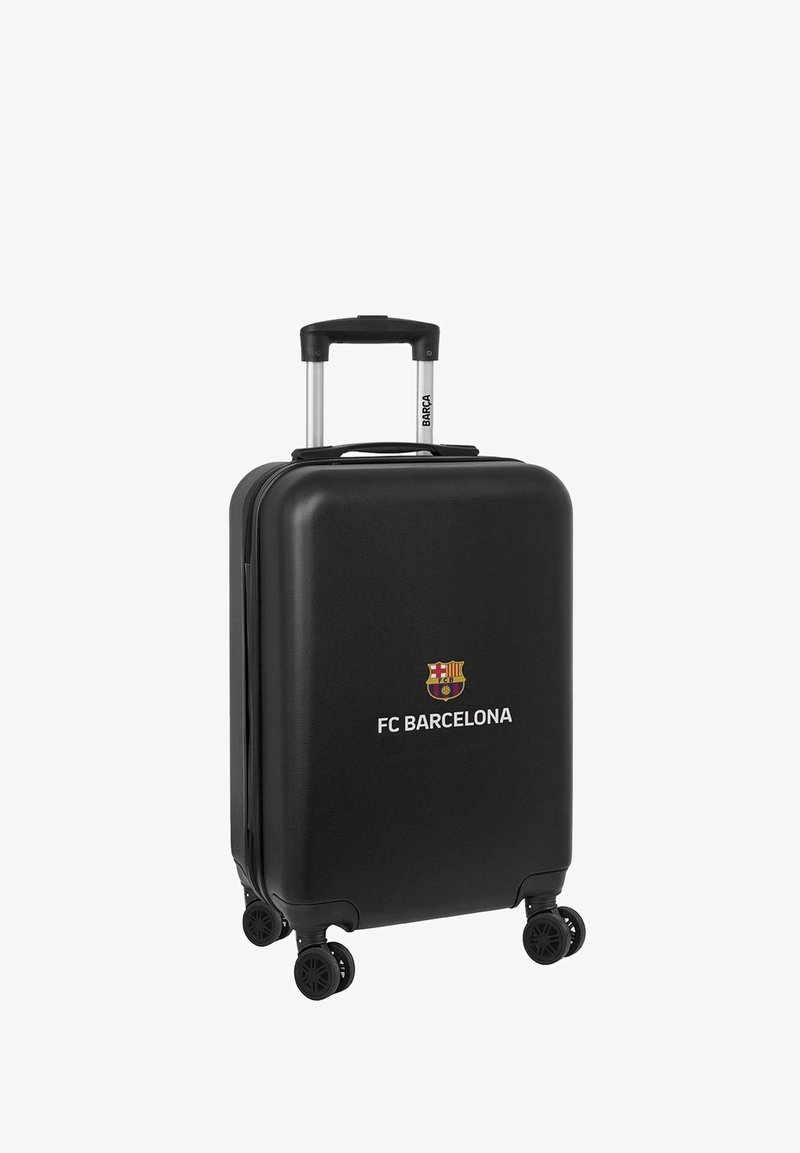 Valise rigide noire avec une texture lisse, arborant un logo du FC Barcelone, une poignée rétractable et quatre roues pour la mobilité.