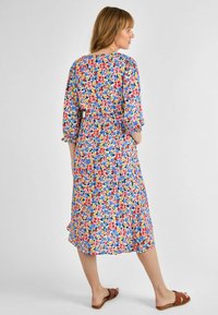 Blumiges Maxikleid mit mehrfarbigem Druck und blauen, roten, gelben und grünen Blumen. Leichter Stoff, 3/4-Ärmel und Taillendetail.