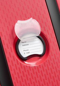 Red textured suitcase with an open ID tag holder displaying a blank personal information card for name, address, phone, and email.