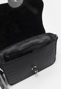 Borsa in pelle con stampa a croco nera, con chiusura in argento, tracolla a catena, fodera interna liscia e tasca con zip.