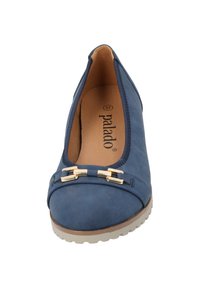 Zapatos planos azul marino con punta redondeada, que cuentan con un acento de herraje en tono oro y una suela texturizada para mayor tracción. Material sintético suave.