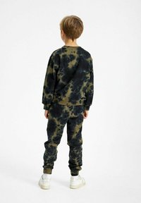 Kids' tie-dye trainingspak in donkergroen en zwart, met elastische boorden en zoom. Zachte katoenen stof, relaxed fit en geribbelde halslijn.
