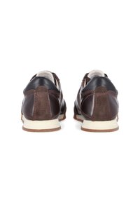Brown leather loafers featuring a suede panel, contrasting black leather accents, stitching details, and a light-colored rubber sole.