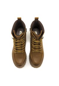 Botas de senderismo de cuero marrón con cordones amarillos, forro marrón texturizado y suela resistente. Cuentan con cremalleras y un diseño de puntera reforzado.
