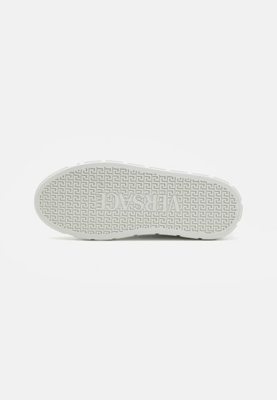 White sneaker outsole with geometric pattern, featuring raised logo and textured surface for grip. Rounded toe and smooth edges.