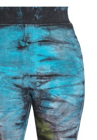 Leggins s plavim i crnim tie-dye uzorkom, glatke teksture i širokim crnim pojasom, s prilagođenim dizajnom i rastezljivim materijalom.