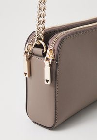 Rectangulaire handtas van taupe leer met een gladde textuur, voorzien van gouden ritsbeslag en een robuuste kettinghengsel.