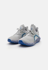 Gray athletic shoes with mesh upper, blue accents, and patterned rubber sole featuring a textured design and lace-up closure.