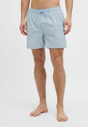 Shorts de bain bleu clair avec une taille élastique, un cordon de serrage et des poches latérales, fabriqués dans un tissu lisse et à séchage rapide.