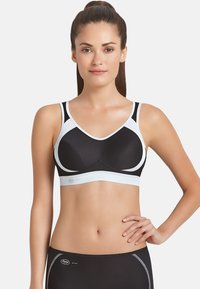 Black sports bra with white accents, molded cups, and wide straps. Features a smooth, breathable fabric and elastic band for support.