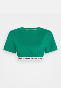 Vihreä lyhythelmainen t-paita, joka on valmistettu puuvillasta. Paidan ominaisuuksia ovat pyöreä kaula-aukko, lyhyet hihat ja resori helmassa, jossa lukee "TOMMY JEANS."