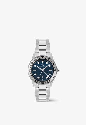 Montre-bracelet en métal argenté avec cadran bleu, index ronds, affichage de la date à 6 heures et chiffres du cadran 24 heures sur bracelet en acier inoxydable.