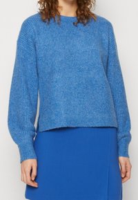 Blauer Strickpullover mit langen Ärmeln, Rundhalsausschnitt und leicht verkürztem Saum. Der Stoff zeigt eine weiche Textur in einheitlicher Farbe.