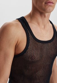 Sort mesh tank top med brede stropper, der har et åbent strikkemønster og en tætsiddende silhuet. Teksturen er åndbar, og stoffet er let.