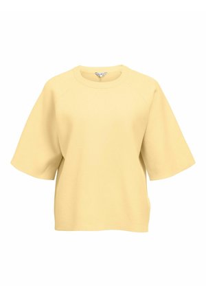 Ohlapna bledo rumena majica s kratkimi rokavi in okroglim izrezom ter raglanskimi šivi, izdelana iz mehkega blaga.