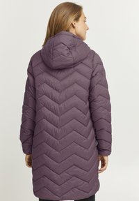Lange, paarse pufferjas met een chevronpatroon, voorzien van een capuchon en mouwen tot aan de elleboog, ontworpen voor warmte en comfort.
