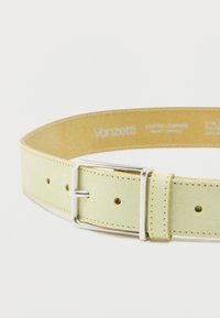 Ζωνη από σουέτ δέρμα σε ανοιχτό κίτρινο χρώμα με ασημένια ορθογώνια αγκράφα και πολλαπλές τρύπες ρύθμισης, με το εμπορικό σήμα "Vanzetti" στο εσωτερικό.