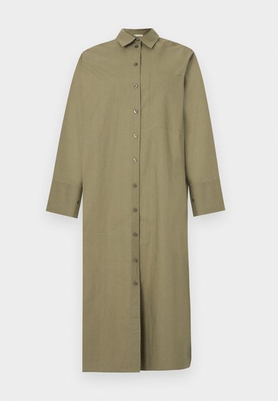 Μακρύ πουκάμισο-φόρεμα σε ελιά πράσινο χρώμα με κουμπιά, μακριά μανίκια και κλασικό γιακά, παρουσιάζεται σε λευκό φόντο.