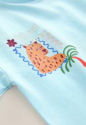 Helles blaues Baumwoll-T-Shirt mit einem Leoparden-Graphic, einer Palme und floralen Akzenten. Verfügt über bunte Drucke und einen runden Ausschnitt.