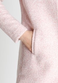 Helles, pinkfarbenes Textur-Jackett mit einer weichen, flauschigen Oberfläche. Verfügt über eine seitliche Tasche und ein tailliertes Ärmel-Design.