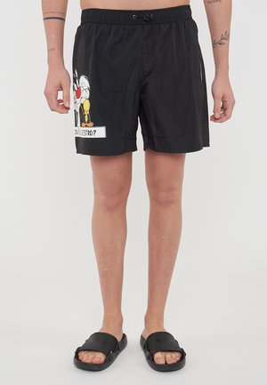 Pantaloni da bagno neri con vita elasticizzata, cordino e tasche laterali. Presentano una grafica a cartone animato di Silvestro e Titti sulla gamba sinistra.