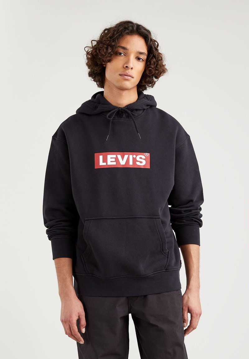 Čierna kapucňová mikina vyrobená z bavlnenej zmesi s červeným obdĺžnikovým logom a bielym textom "LEVI'S" na prednej strane. Klokaní vrecko a rebrované manžety.