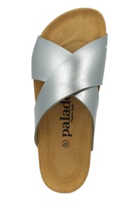 Sandalia deslizante de imitación de cuero plateado con correas cruzadas, plantilla de corcho y logotipo de la marca en negro sobre una plantilla beige. Diseño de suela plana.