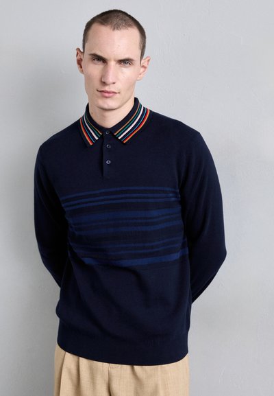Navy pullover with a striped collar, featuring horizontal stripes in varying shades of blue across the chest. Soft texture, tailored fit.