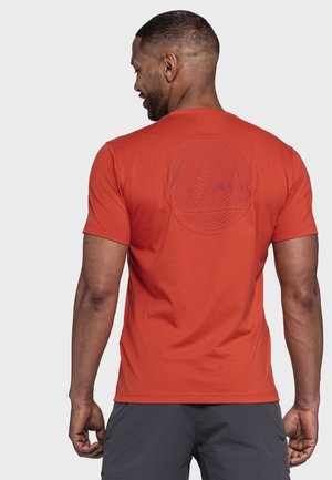 Rotes T-Shirt mit kurzen Ärmeln und kreisförmigen Grafiken auf dem Rücken, aus glattem Material, kombiniert mit grauen Shorts.